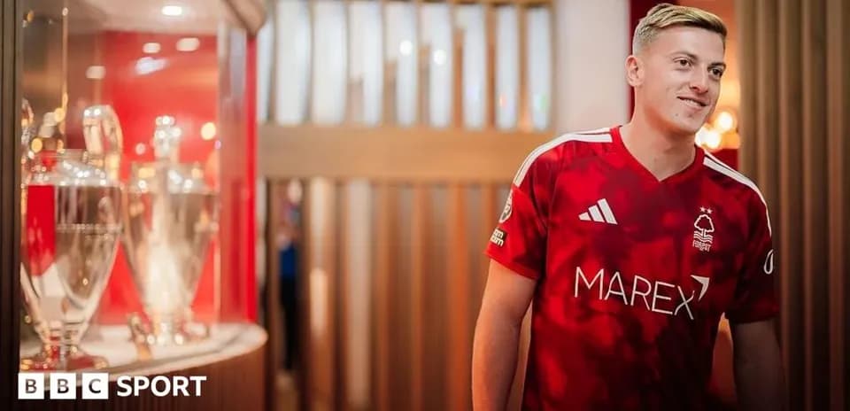 Player in Nottingham Forest jersey near trophies