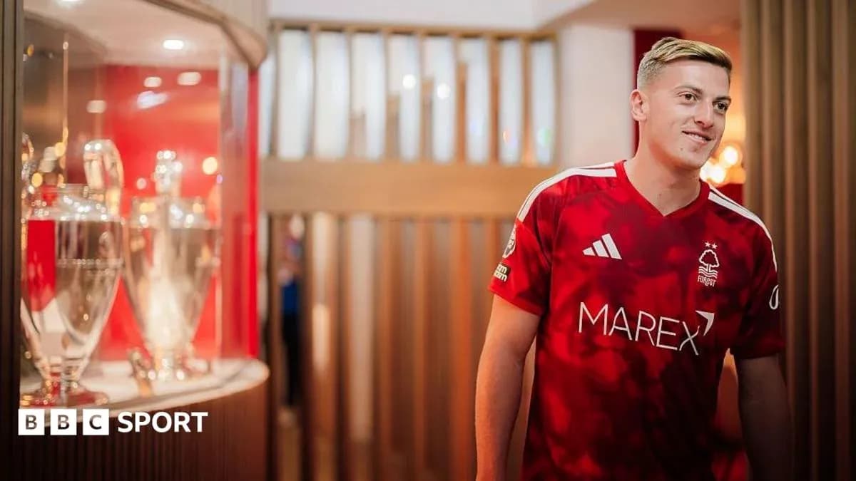 Player in Nottingham Forest jersey near trophies