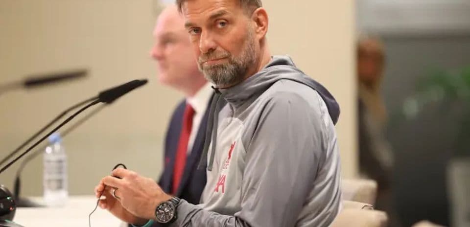 Manager sitting at press conference table with microphone