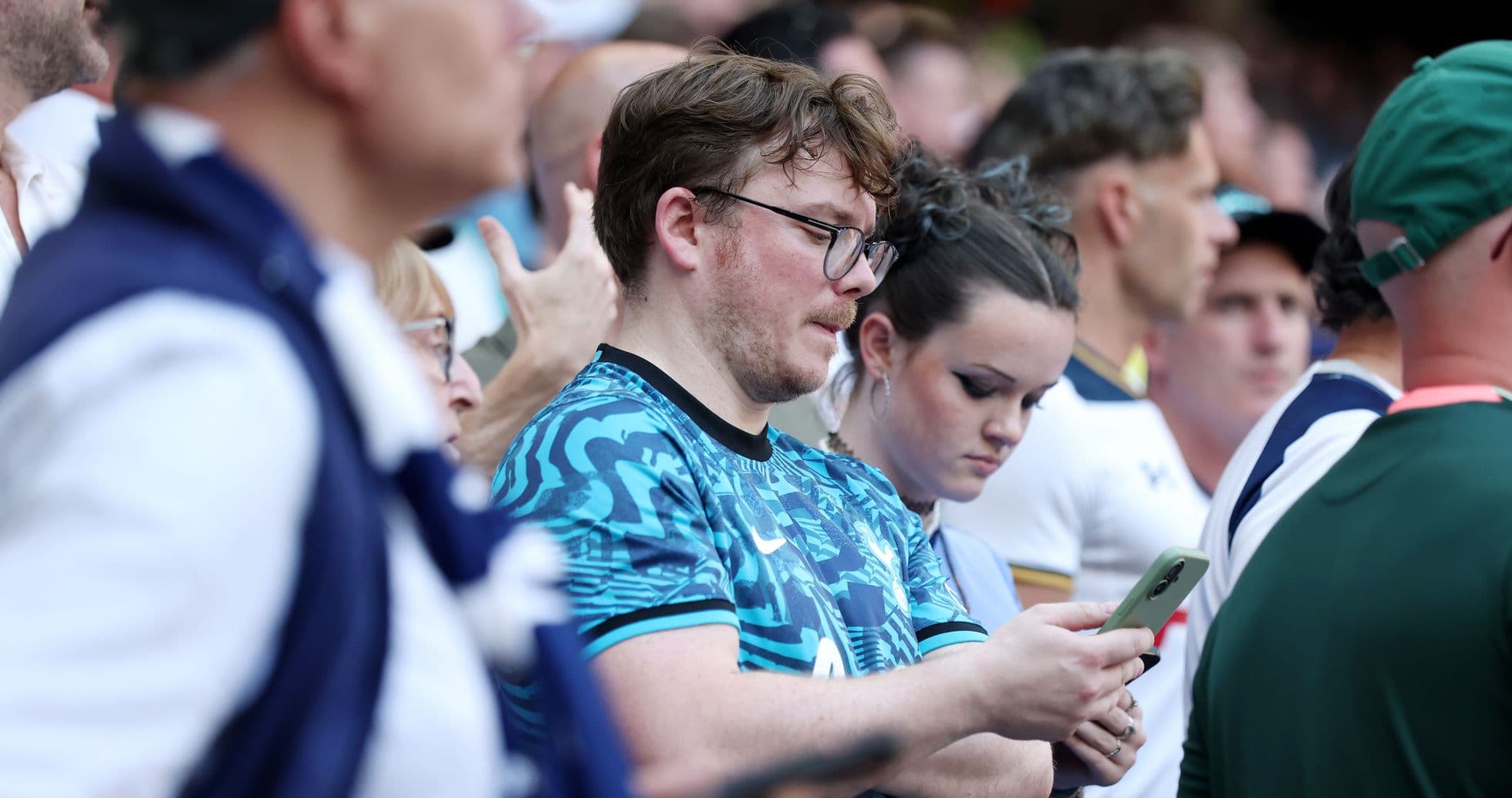 Fans watching the match, some using smartphones
