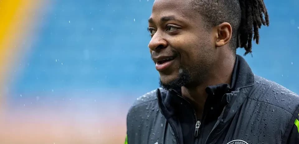 Player smiling during rainy training session outdoors