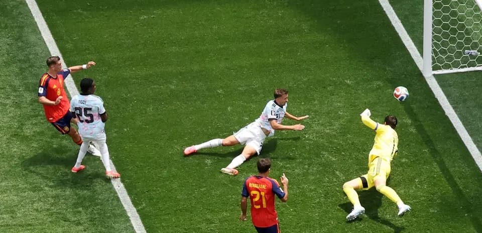 Player shooting on goal as goalkeeper dives to save