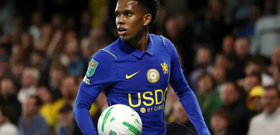 Player in blue jersey holding soccer ball on field
