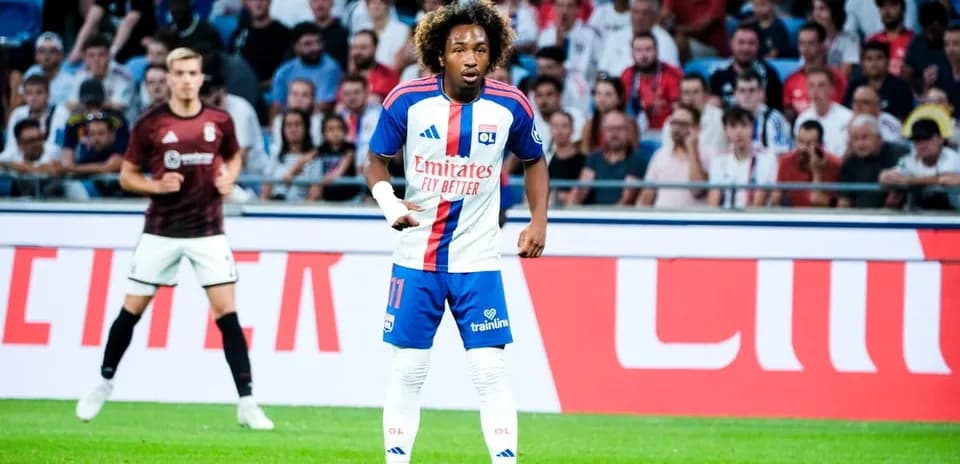 Player wearing Lyon kit during match with crowd behind