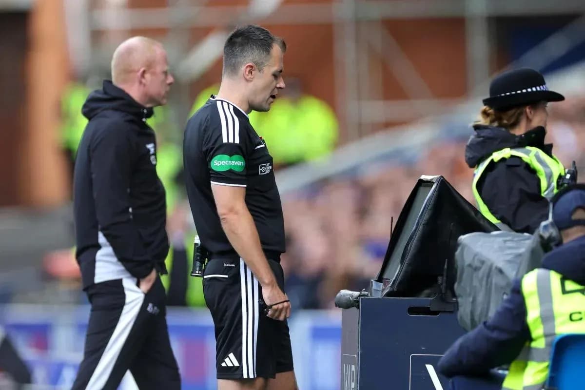 Referee reviewing play at VAR monitor during match