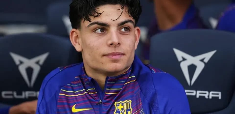 Player seated on bench wearing FC Barcelona kit