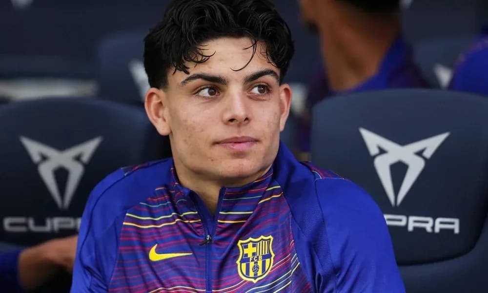 Player seated on bench wearing FC Barcelona kit