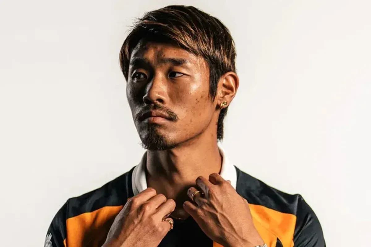 Player posing in sports jersey against plain background