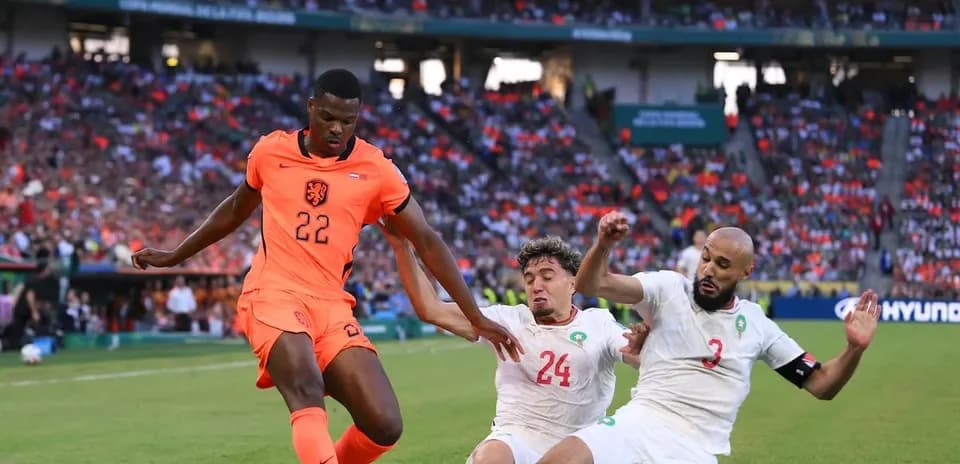 Player 22 from Netherlands dribbling past two defenders