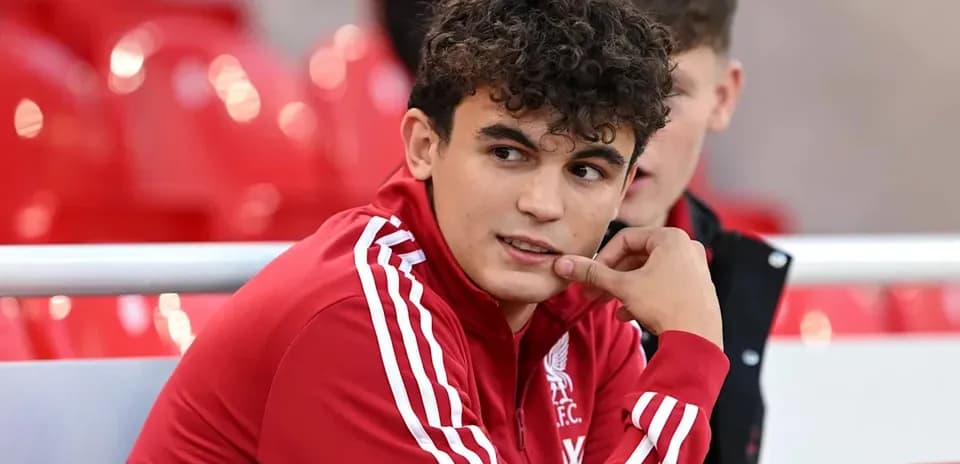 Player in Liverpool FC training kit on bench