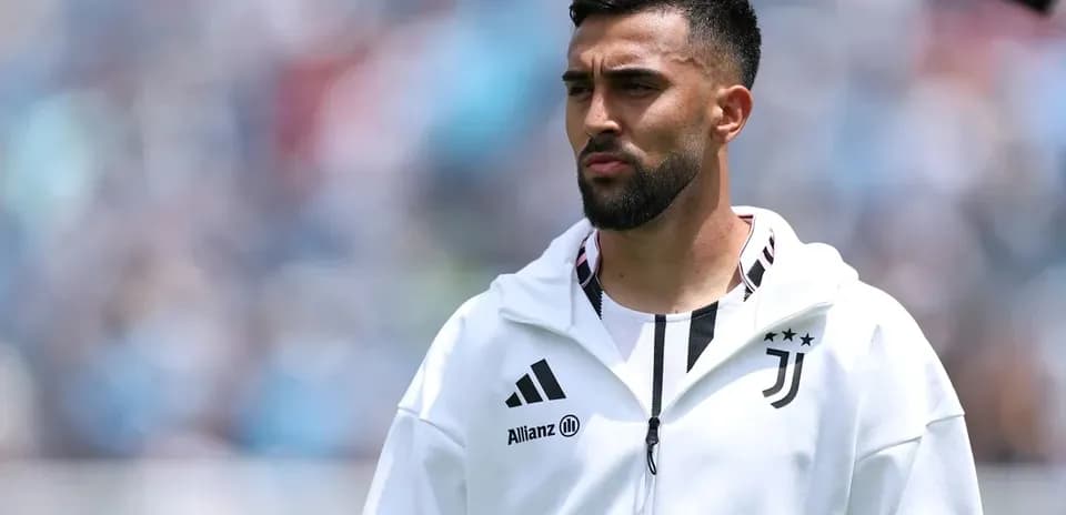 Player in Juventus hoodie on the sidelines