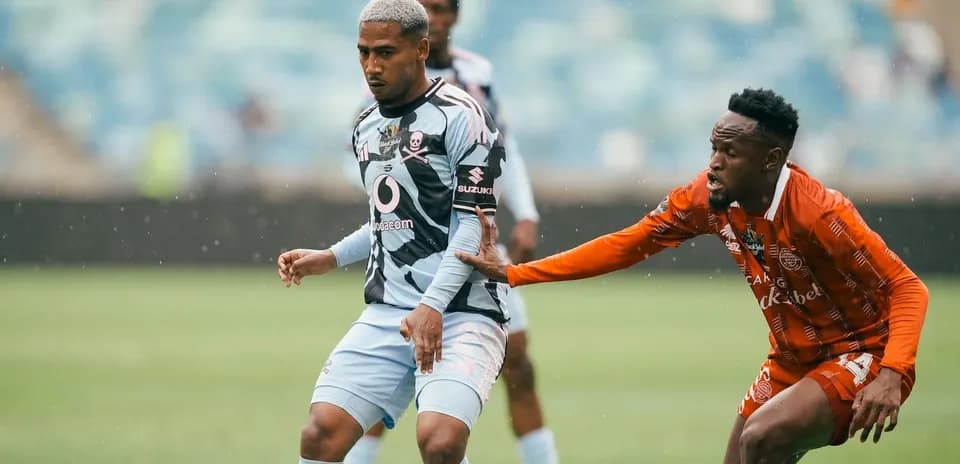 Player in blue jersey being challenged by opponent