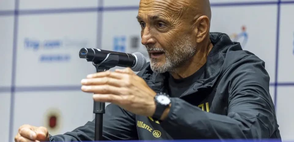 Coach speaking at press conference with microphone