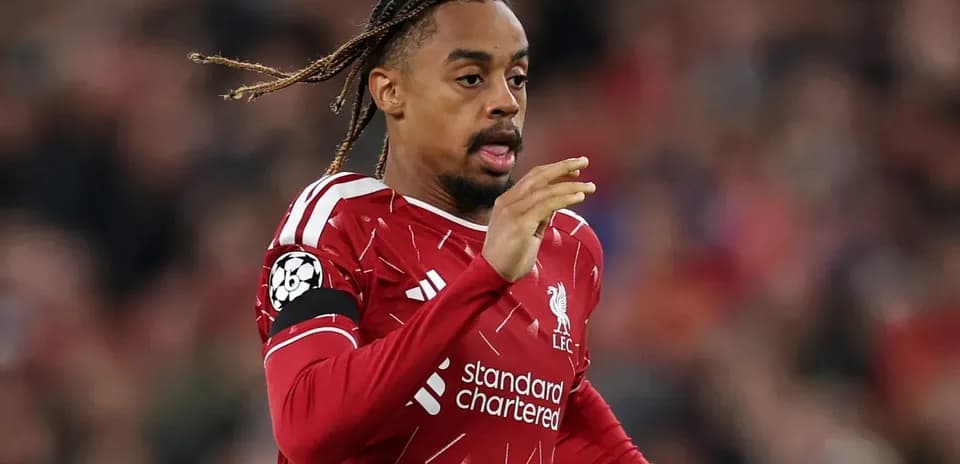 Player running on the pitch in Liverpool kit