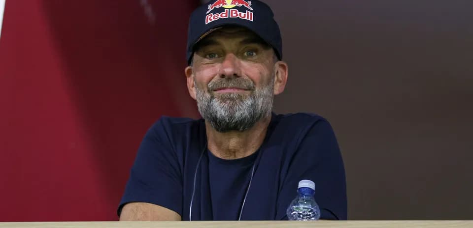Man with beard wearing Red Bull cap in stands