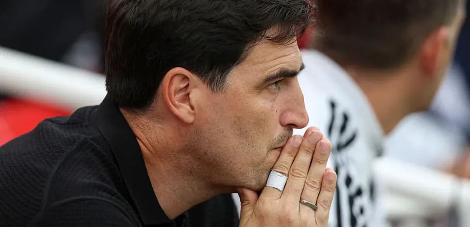 Coach observing the match with focused expression