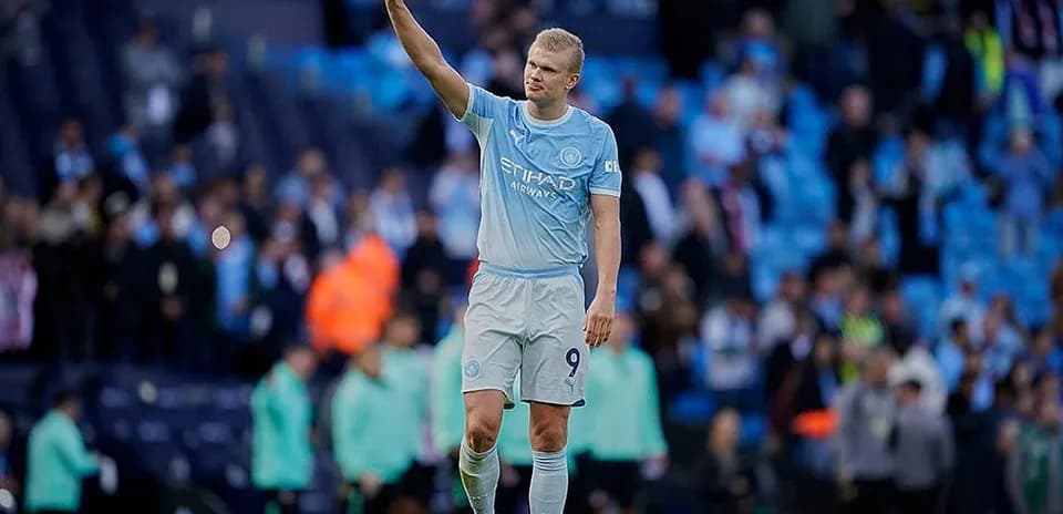 Player waving to fans at Manchester City match