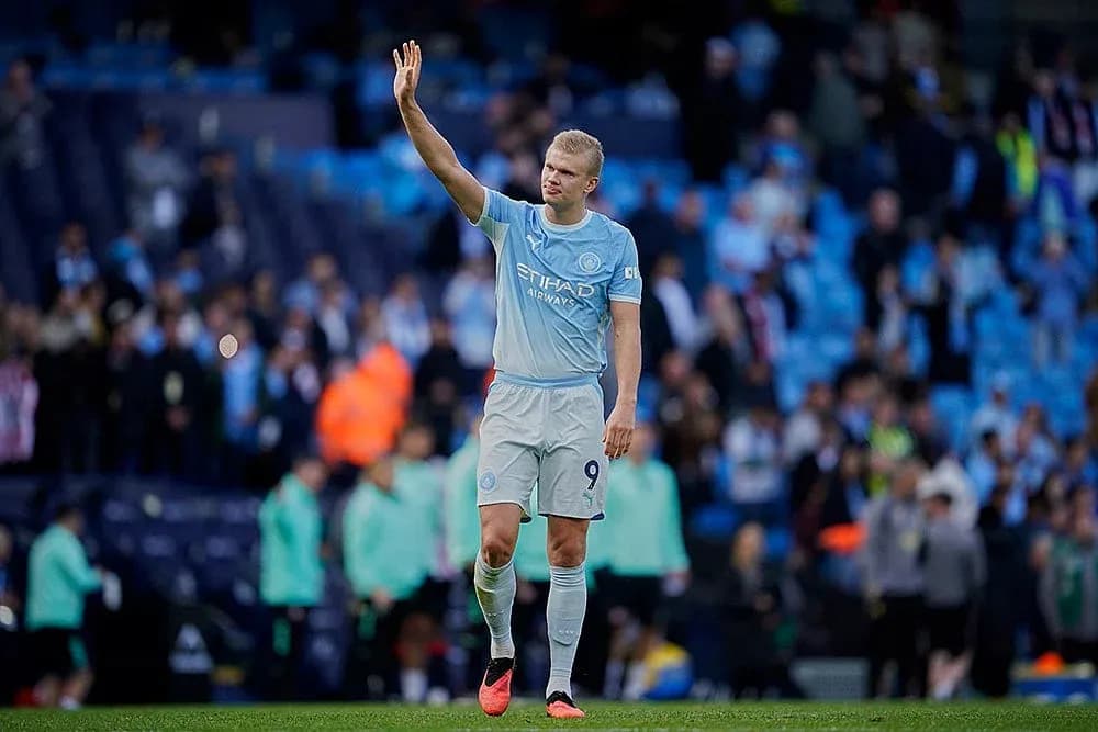 Player waving to fans at Manchester City match