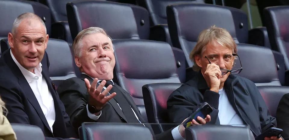 Coaches seated in stands during match observation