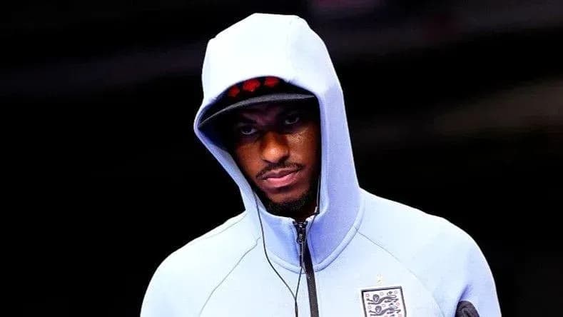 Player in blue hoodie entering stadium