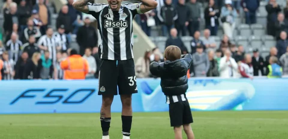 Newcastle player celebrating with child on pitch