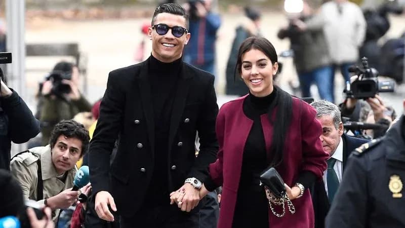 Couple walking hand in hand with photographers present