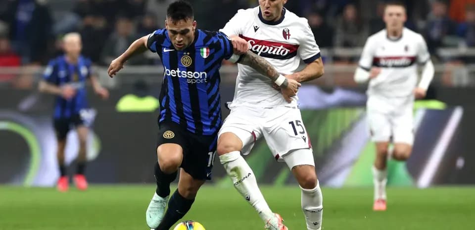 Bologna player challenging Inter player for the ball