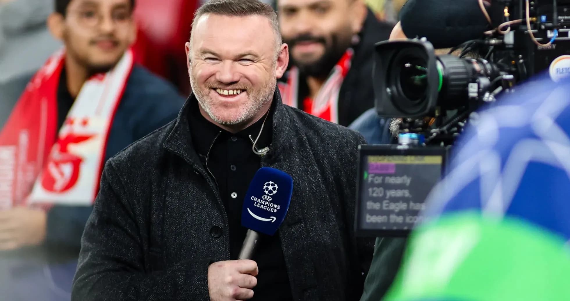 Presenter smiling with microphone at football event