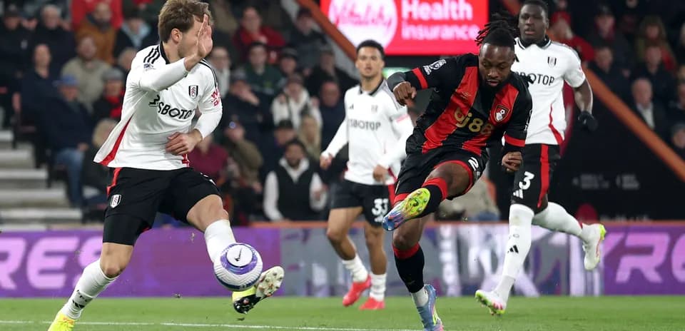 Fulham player challenging Bournemouth player during match