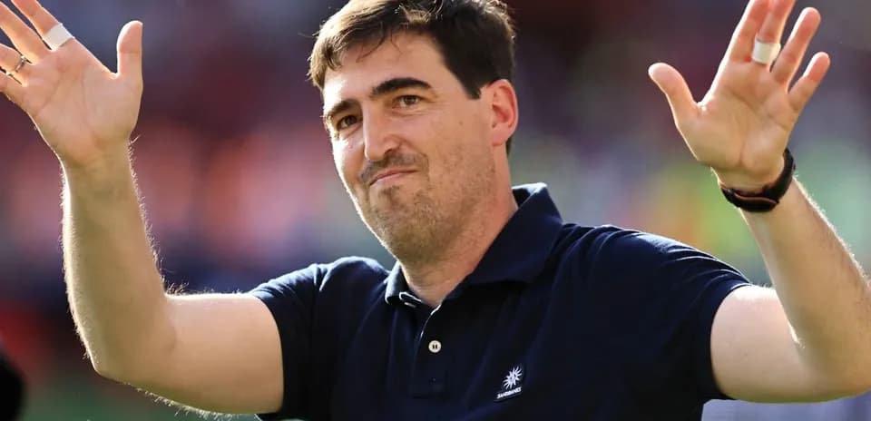 Coach gesturing to fans after match conclusion