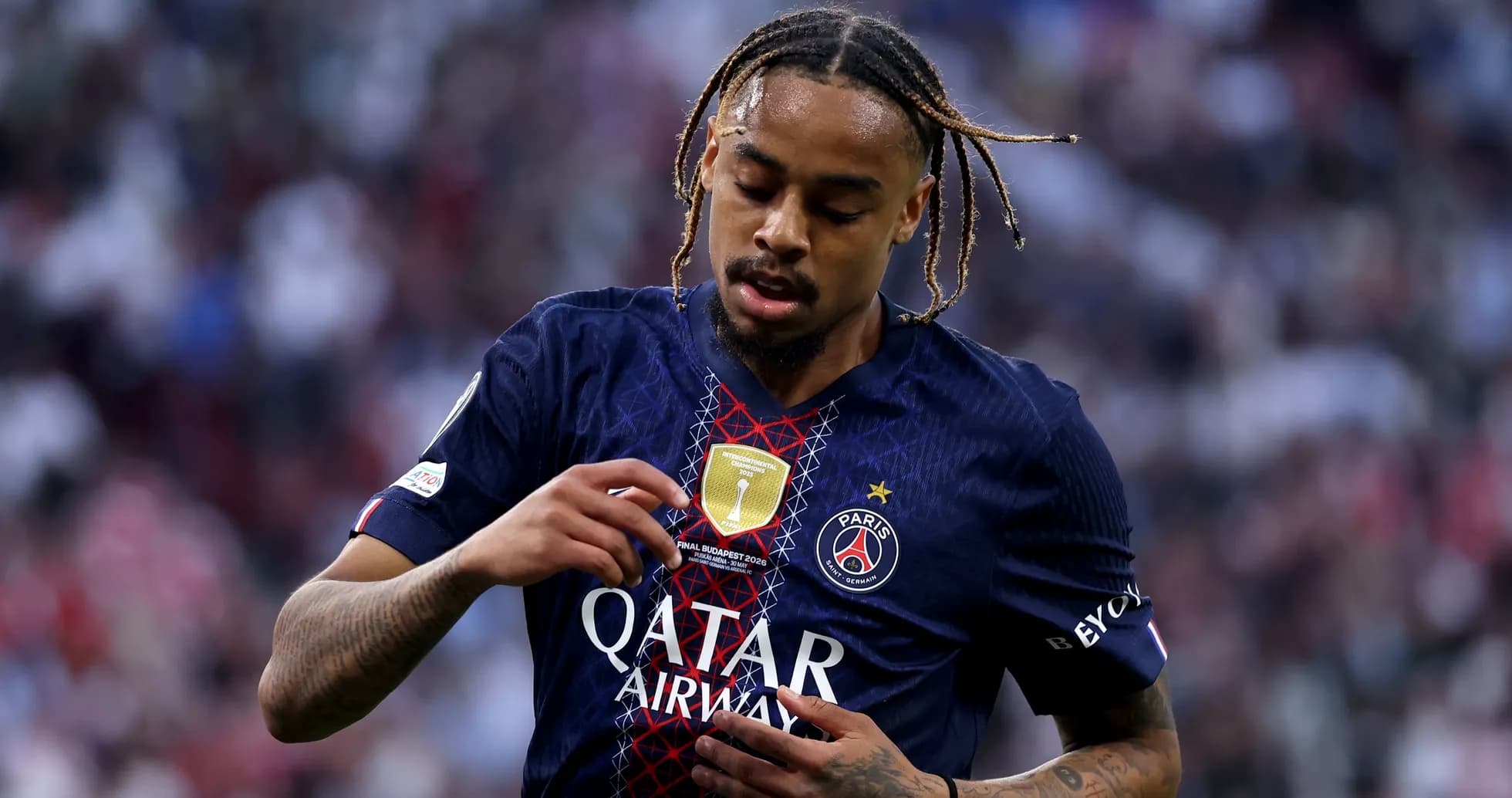 Player adjusting badge on Paris Saint-Germain jersey