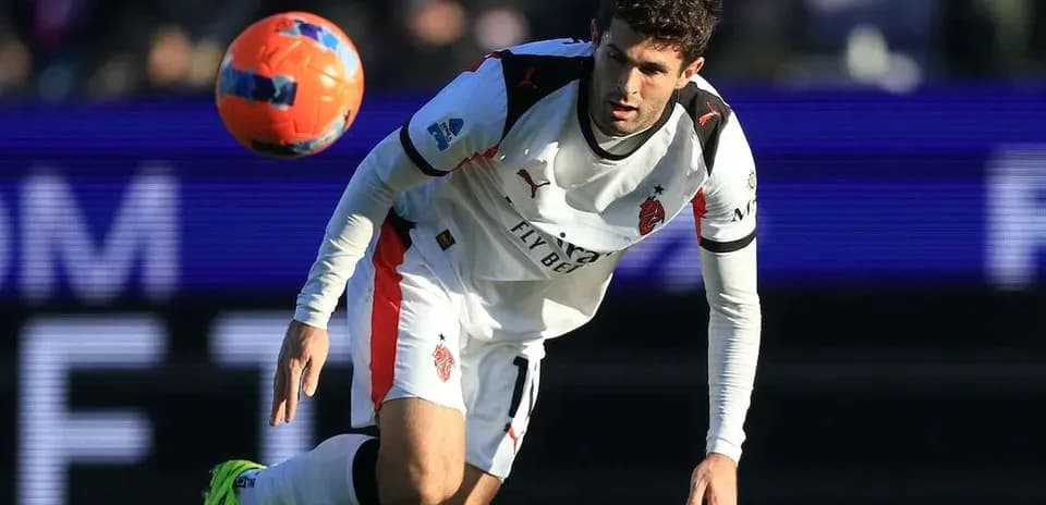 Player in white kit controlling a soccer ball