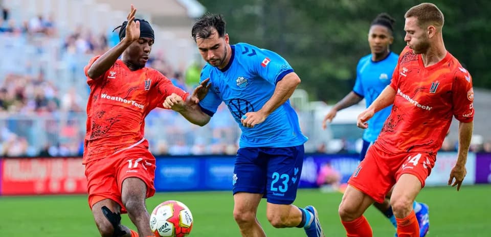 Two players competing for the ball in football match