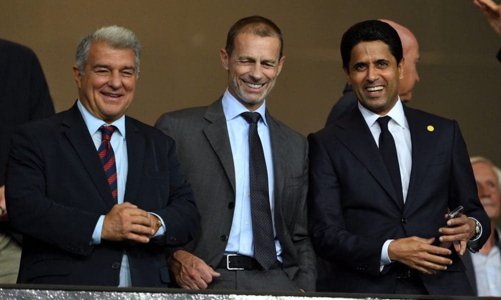 Three officials smiling in a stadium box