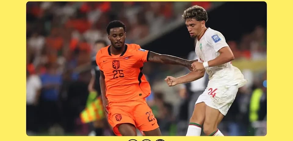 Player in orange and player in white competing for ball