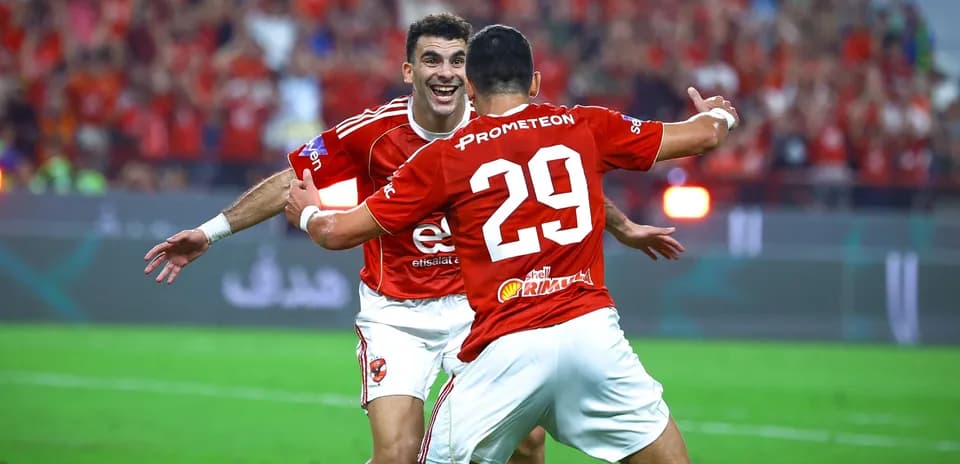 Two players celebrating a goal on the field