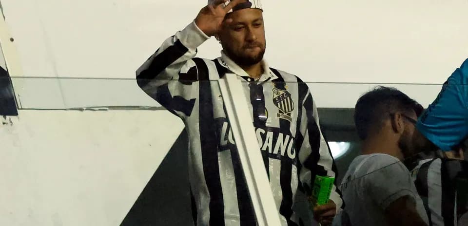 Fan waving from the stands wearing Santos jersey