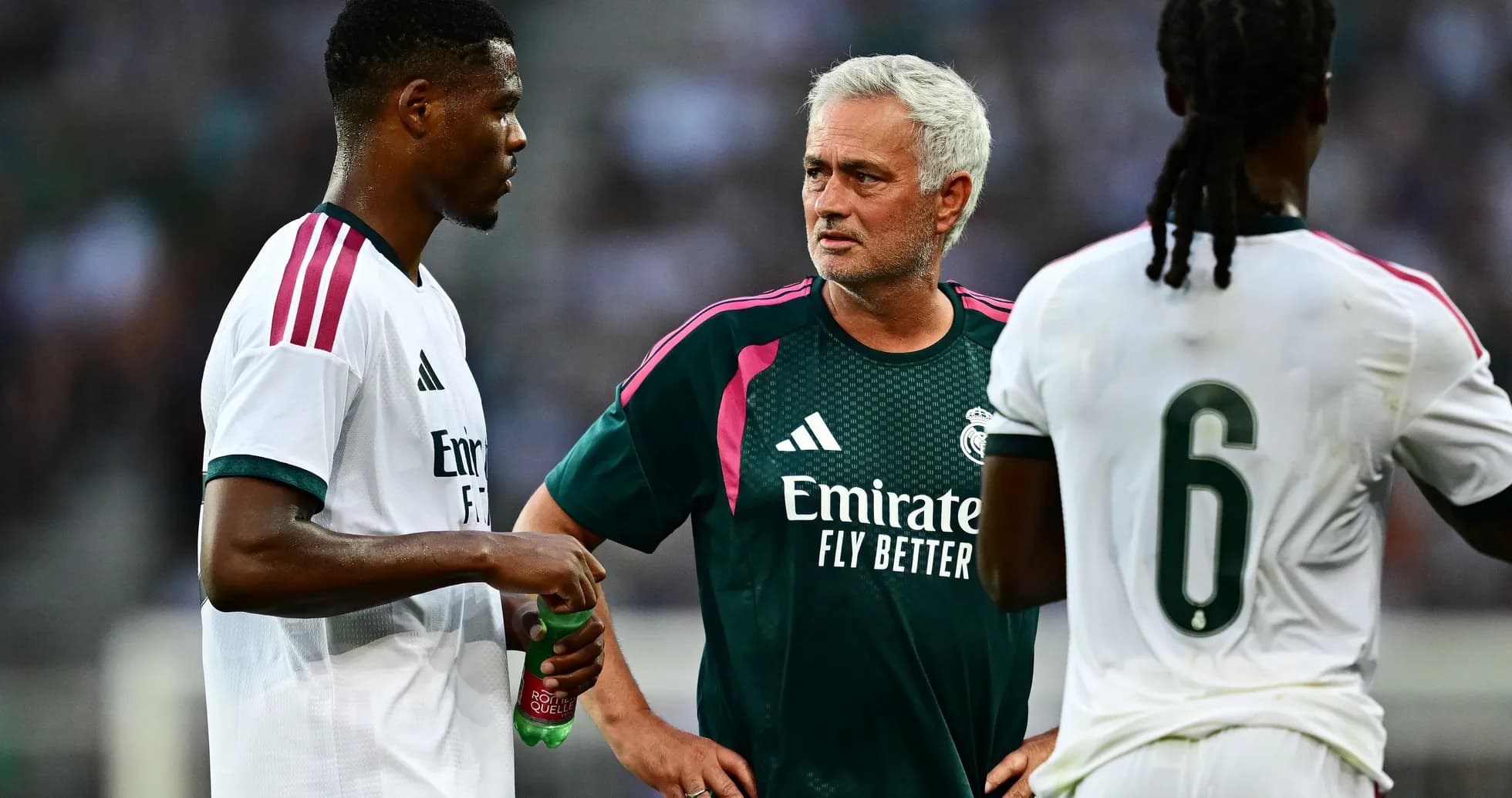 Manager discussing strategy with two players during training