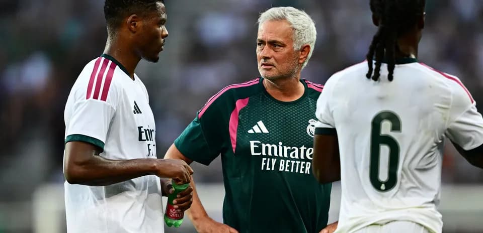 Manager discussing strategy with two players during training