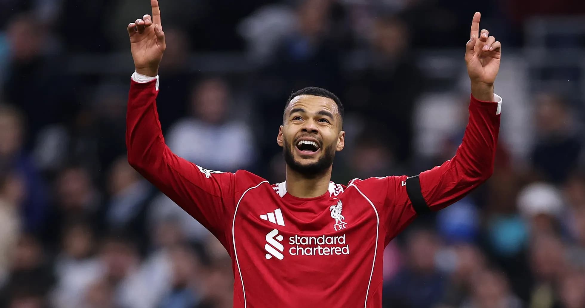 Player celebrating with arms raised in Liverpool kit