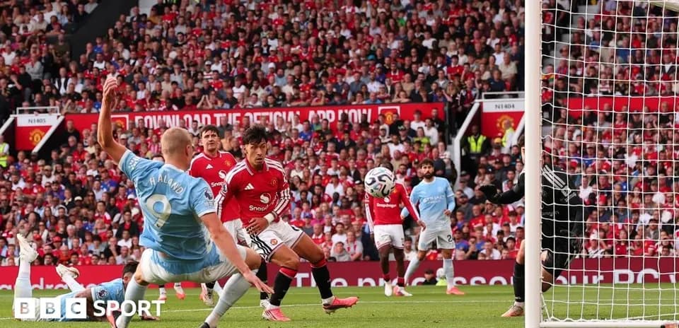Player striking ball during Manchester derby match