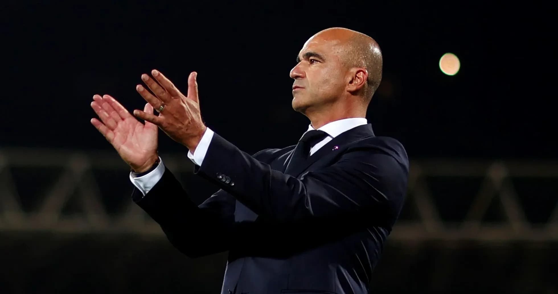 Coach applauding during a match from the sidelines