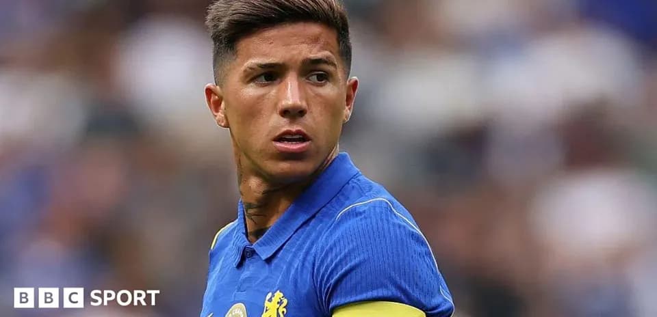 Player wearing blue jersey and captain armband on field
