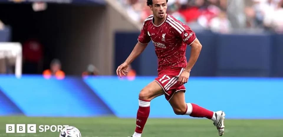 Player in red kit running with soccer ball