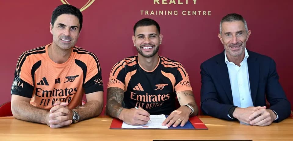 Player signing contract with club officials at table