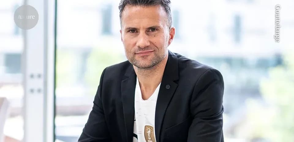 Man in a black suit posing for the camera
