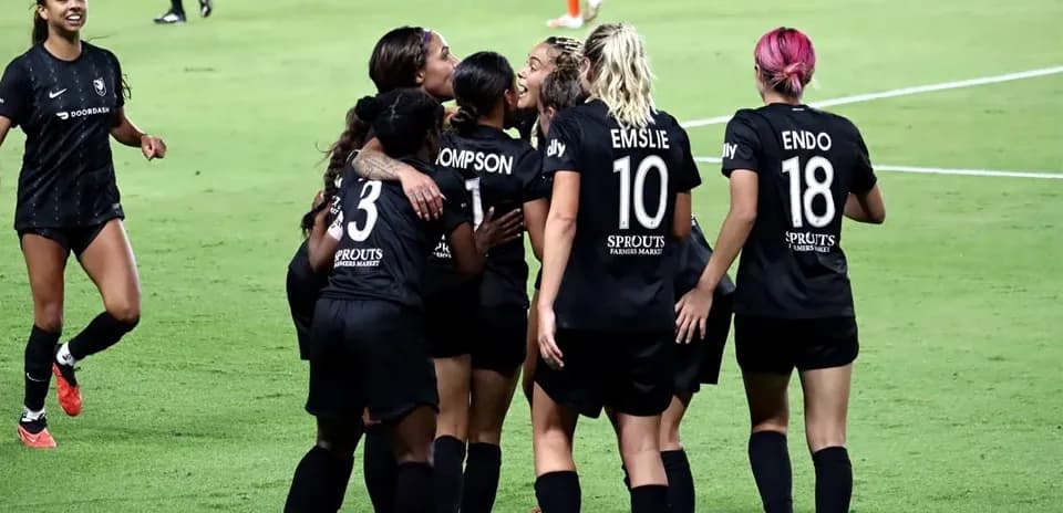 Players celebrating a goal during NWSL match