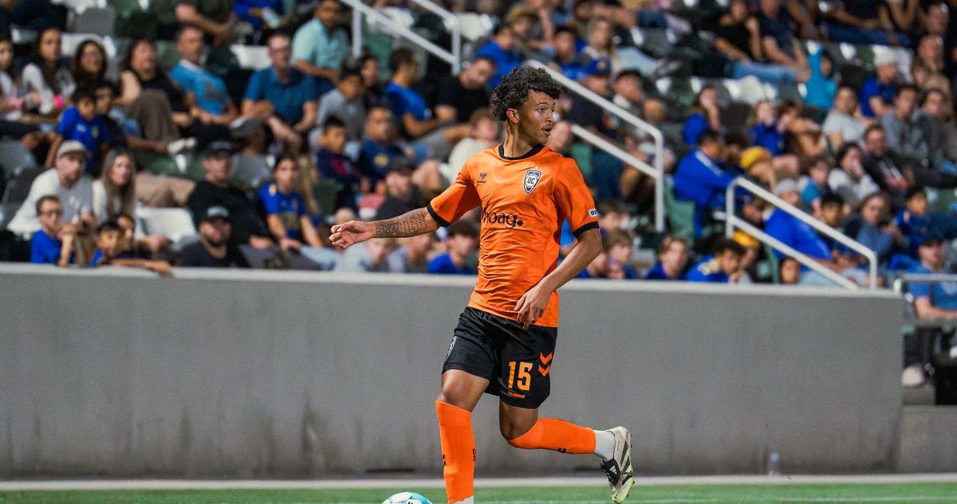Player in orange jersey running with ball