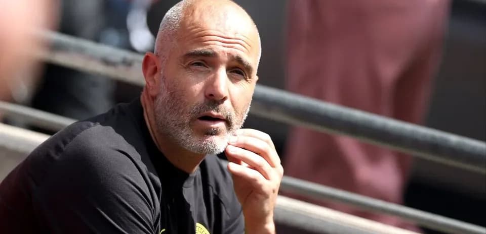 Coach observing match from sidelines during game
