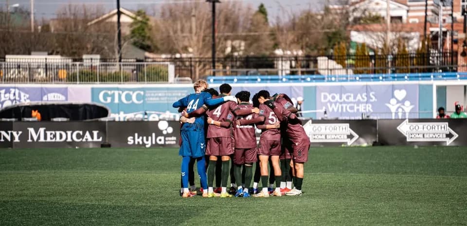 Players huddled together before the match